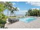 Inviting pool area with a waterfall feature, comfortable lounge chairs, and scenic water views at 11327 Lake Lucaya Dr, Riverview, FL 33579