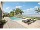 Backyard pool and patio with lounge chairs, a serene waterfall feature, and beautiful landscaping at 11327 Lake Lucaya Dr, Riverview, FL 33579