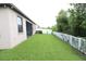 Large grassy backyard area with a white picket fence at 11617 Brighton Knoll Loop, Riverview, FL 33579
