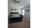 Comfortable bedroom with a dark wood bed frame, neutral-toned walls, carpet, and ceiling fan at 11617 Brighton Knoll Loop, Riverview, FL 33579