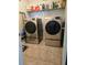 Well-organized laundry room featuring updated washer and dryer units with storage shelving at 11617 Brighton Knoll Loop, Riverview, FL 33579