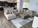 Spacious living room featuring an L-shaped couch, patterned rug, and an open layout with a kitchen view at 11617 Brighton Knoll Loop, Riverview, FL 33579