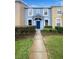Charming two-story townhome featuring a blue facade, manicured landscaping, and inviting entryway at 1237 Blenheim Ct, Wesley Chapel, FL 33543
