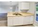 Kitchen view showcasing double stainless sink, white cabinets, dishwasher and eat-in breakfast bar at 1237 Blenheim Ct, Wesley Chapel, FL 33543
