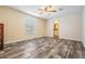 Bright bedroom with wood floors, a window for natural light, and a door leading to an en-suite bathroom at 13039 Keel Ct, Hudson, FL 34667