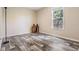 Guest bedroom with plank flooring, natural light, and a wooden accent table with storage and lighting at 13039 Keel Ct, Hudson, FL 34667