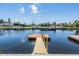 A view of the dock with calm water, houses in the background and a beautiful sky at 13039 Keel Ct, Hudson, FL 34667