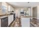 Modern kitchen featuring stainless steel appliances, white cabinets, granite counters, and wood flooring at 13039 Keel Ct, Hudson, FL 34667