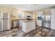 Modern kitchen featuring stainless steel appliances, white cabinets, granite counters, and wood flooring at 13039 Keel Ct, Hudson, FL 34667