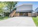 Open lower-level parking features an extra-large concrete pad, direct house access, and lush lawn at 13039 Keel Ct, Hudson, FL 34667