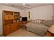 Bright bedroom features comfortable furniture, a ceiling fan, and a window with plantation shutters at 13878 Oak Forest N Blvd, Seminole, FL 33776