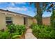 Inviting front entrance framed by lush greenery and a stone path to a charming door at 13878 Oak Forest N Blvd, Seminole, FL 33776
