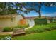 Welcoming single-story home featuring a charming bench and vibrant, green landscaping at 13878 Oak Forest N Blvd, Seminole, FL 33776