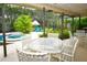 Covered patio with tropical landscaping, grill, pool table, and outdoor seating, great for entertaining at 13878 Oak Forest N Blvd, Seminole, FL 33776