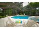 Inviting screened-in pool area with comfortable lounge chairs for relaxing by the crystal-clear water at 13878 Oak Forest N Blvd, Seminole, FL 33776