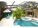 Enjoy the outdoors in this screened pool area with ample seating, spa, and lush tropical landscaping at 13878 Oak Forest N Blvd, Seminole, FL 33776