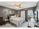 Comfortable bedroom with modern decor, ceiling fan, and sliding glass door to a balcony at 14107 Mossy Glen Ln # 203, Tampa, FL 33613
