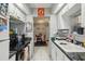 Cozy kitchen featuring white cabinets, black appliances, and view of dining room at 14107 Mossy Glen Ln # 203, Tampa, FL 33613