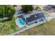 Aerial view of a home with solar panels on roof and a kidney-shaped swimming pool at 15100 Avalon Ave, Clearwater, FL 33760