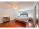 Well-lit bedroom featuring hardwood floors, a window view, and mirrored closet doors at 15100 Avalon Ave, Clearwater, FL 33760