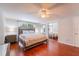Comfortable bedroom featuring a ceiling fan, mirrored closet doors, and hardwood floors at 15100 Avalon Ave, Clearwater, FL 33760