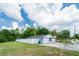 Home with a one-car garage and tidy landscaping, all enclosed by a white privacy fence at 15100 Avalon Ave, Clearwater, FL 33760