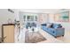 Bright living room features stylish blue furniture, a glass coffee table, and sleek marble floors at 15100 Avalon Ave, Clearwater, FL 33760