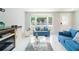 Inviting living room with comfortable blue sofas, a decorative glass table, and bright natural light at 15100 Avalon Ave, Clearwater, FL 33760