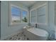 Elegant bathroom featuring a soaking tub with scenic waterfront views from the large windows at 15805 Redington Dr, Redington Beach, FL 33708