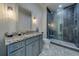 Elegant bathroom featuring a stylish vanity, patterned floor tiles, and a modern glass-enclosed shower at 15805 Redington Dr, Redington Beach, FL 33708