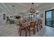 Elegant dining area boasts a wood table, seating for eight, and sliding glass doors with water views at 15805 Redington Dr, Redington Beach, FL 33708