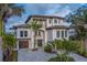 Beautiful Mediterranean-style home with a large driveway, garage, and manicured landscaping at 15805 Redington Dr, Redington Beach, FL 33708