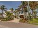 Stately exterior of home with large, manicured yard with mature landscaping and decorative driveway at 15805 Redington Dr, Redington Beach, FL 33708