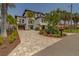 Stately exterior of home with large, manicured yard with mature landscaping and decorative driveway at 15805 Redington Dr, Redington Beach, FL 33708