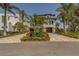Stately exterior of home with large, manicured yard with mature landscaping and decorative driveway at 15805 Redington Dr, Redington Beach, FL 33708