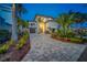 Elegant home with a well-maintained lawn and a paved driveway at twilight at 15805 Redington Dr, Redington Beach, FL 33708