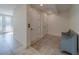 Bright hallway featuring neutral tile flooring, white doors, a vintage bench, and an ornate glass door to the outside at 15805 Redington Dr, Redington Beach, FL 33708