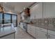 Gourmet kitchen featuring sleek white cabinetry, stainless steel appliances, and stylish tile backsplash at 15805 Redington Dr, Redington Beach, FL 33708