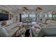Bright living room with plush seating, entertainment center, and sliding glass doors to a balcony at 15805 Redington Dr, Redington Beach, FL 33708