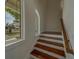 Elegant staircase featuring hardwood steps and natural light from the large window at 15805 Redington Dr, Redington Beach, FL 33708