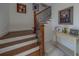 Elegant staircase featuring wood steps, iron railings, and stylish decor creates a welcoming entrance to the home at 15805 Redington Dr, Redington Beach, FL 33708