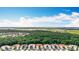 An aerial view of a neighborhood with homes, trees, and a clear blue sky at 16142 Amethyst Key Dr, Wimauma, FL 33598