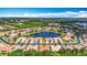 Breathtaking aerial view of homes surrounding a serene lake, set against a backdrop of lush greenery and blue skies at 16142 Amethyst Key Dr, Wimauma, FL 33598