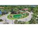 Aerial view of a community entrance with water feature, lush landscaping, and well-maintained roadways at 16142 Amethyst Key Dr, Wimauma, FL 33598