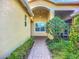 Charming entrance featuring a brick path, lush landscaping, and a covered porch with a pendant light at 16142 Amethyst Key Dr, Wimauma, FL 33598