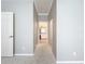 Hallway leading to bathroom with patterned carpet and decorative molding on the ceiling at 16142 Amethyst Key Dr, Wimauma, FL 33598