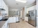 Bright kitchen features white cabinets, stainless steel appliances, and tile flooring at 16142 Amethyst Key Dr, Wimauma, FL 33598