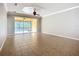 Bright living room features tile flooring, a ceiling fan, and sliding glass doors to a screened lanai at 16142 Amethyst Key Dr, Wimauma, FL 33598