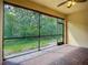 Screened lanai with brick-style flooring, offering a seamless transition to the outdoors and lush greenery at 16142 Amethyst Key Dr, Wimauma, FL 33598