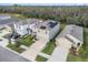 Aerial view of the home featuring solar panels, well-maintained lawns, landscaping, and neighborhood streets at 17012 Oval Rum Dr, Wimauma, FL 33598